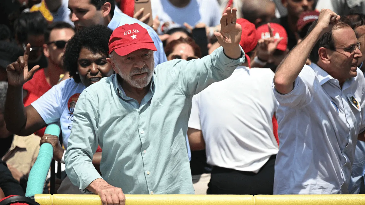Lula saluda desde una camioneta rodeado de una multitud vestida de rojo junto a la playa.